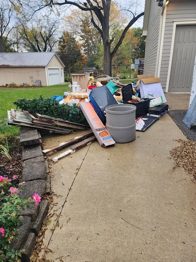 Dumpster being loaded with debris for Estate Cleanout Dumpster Rental in Gibsonville